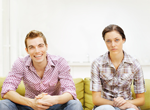 Happy man to his right an unhappy woman both sitting down.